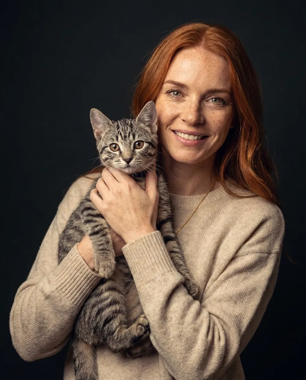 Example AI portrait of the woman holding her tabby kitten against a dark backdrop